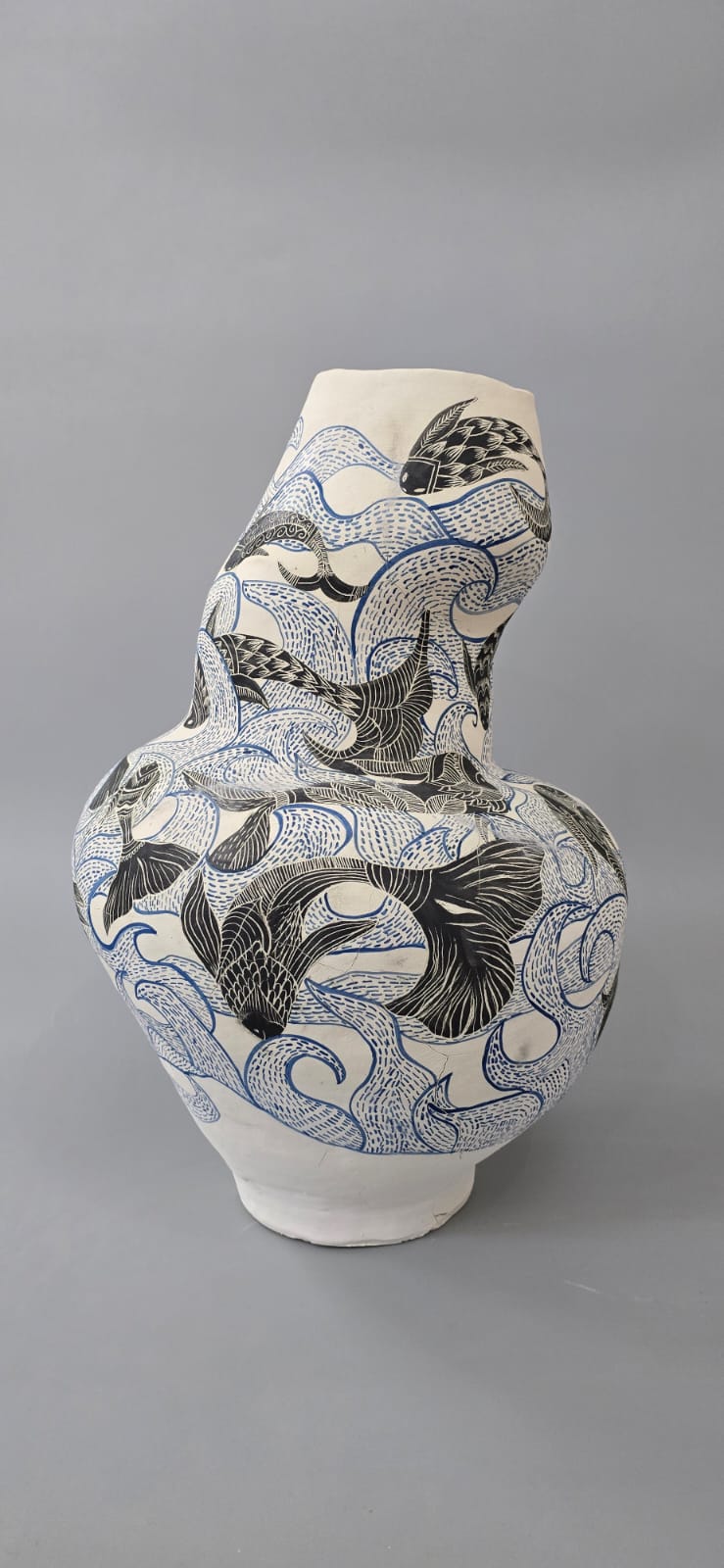 Sculptural ivory ceramic vase with black fish and flowing blue line patterns